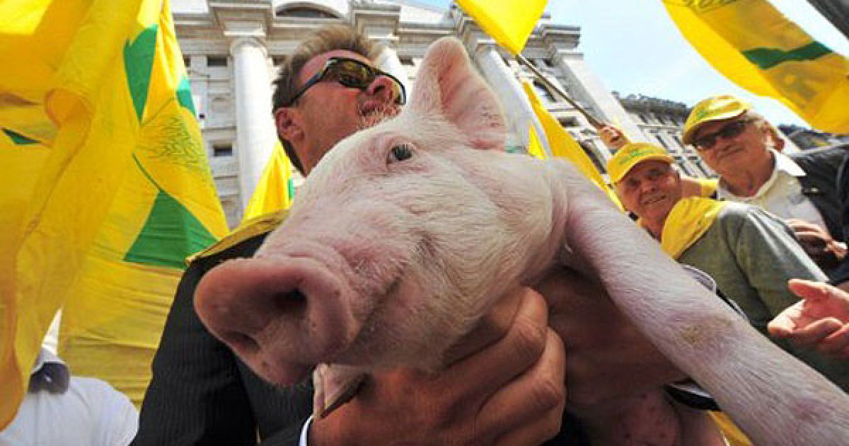 Італія, Мілан. Фермер тримає на руках порося під час акції протесту перед Міланською фондовою біржею. Фермери та члени асоціації фермерів Coldiretti виступили проти складної економічної ситуації в країні. / © AFP
