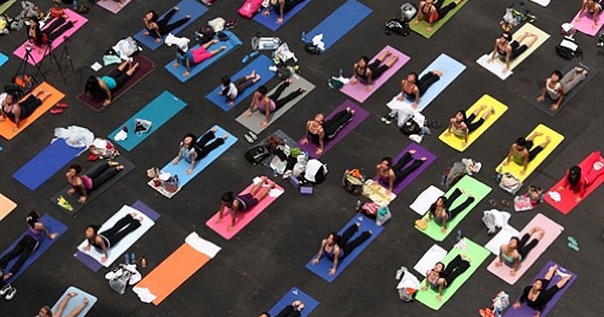 Китай, Гонконг. Люди виконують вправи йоги під час "Йогатону" (Yogathon) в Гонконгу, де провели восьмигодинне безперервне тренування, щоб зібрати гроші для Фонду раку молочної залози. / © AFP