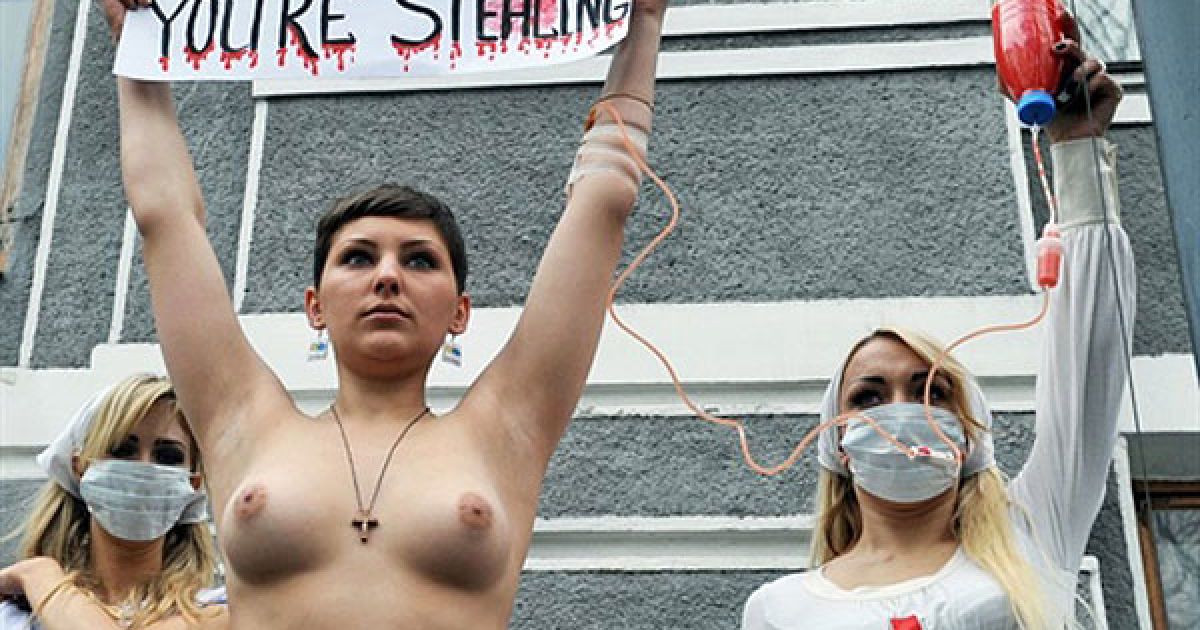 Активістка FEMEN протестувала топлес з плакатами "Я помираю, а ви крадете!", "Епідемія раку совісті", "Momento mori, Yemets!" і "У мене рак, міністре дурак". / © AFP