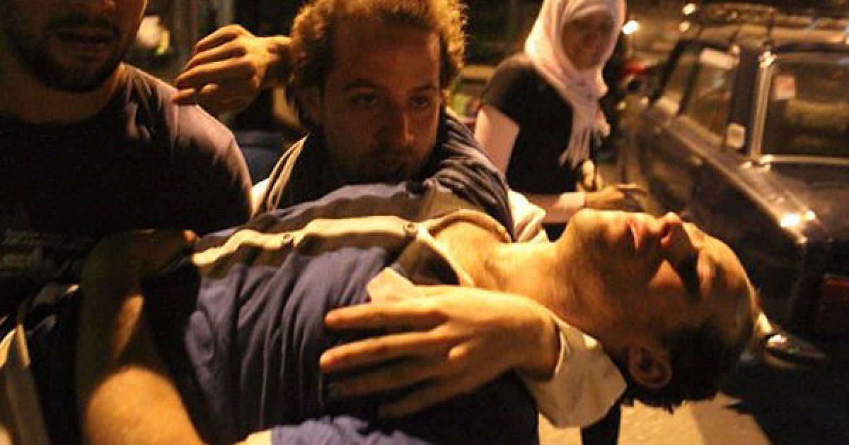 Єгипет, Каїр. Єгипетські демонстранти несуть поранених під час зіткнень з поліцією на площі Тахрір у Каїрі. Сили безпеки Єгипту застосували сльозогінний газ проти демонстрантів в ході запеклих зіткнень. / © AFP