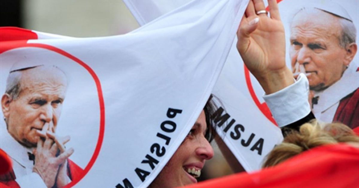 Ватикан. Польські паломники тримають прапори із зображенням Папи Іоана Павла ІІ під час святкової меси на площі Святого Петра. Першого травня Папа Бенедикт XVI зарахував Іоана Павла ІІ до лику блаженних. / © AFP