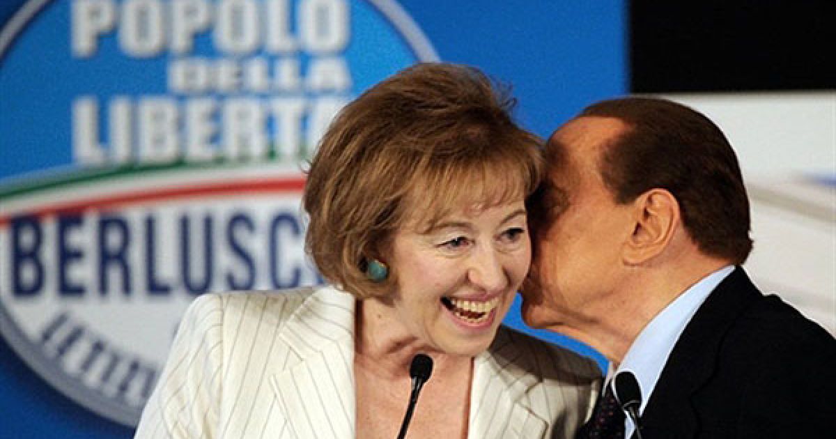 Італія, Мілан. Прем'єр-міністр Італії Сільвіо Берлусконі цілує Летицію Моратті, кандидата від партії "Народ свободи" під час відкриття політичної кампанії на місцевих виборах в Мілані. / © AFP