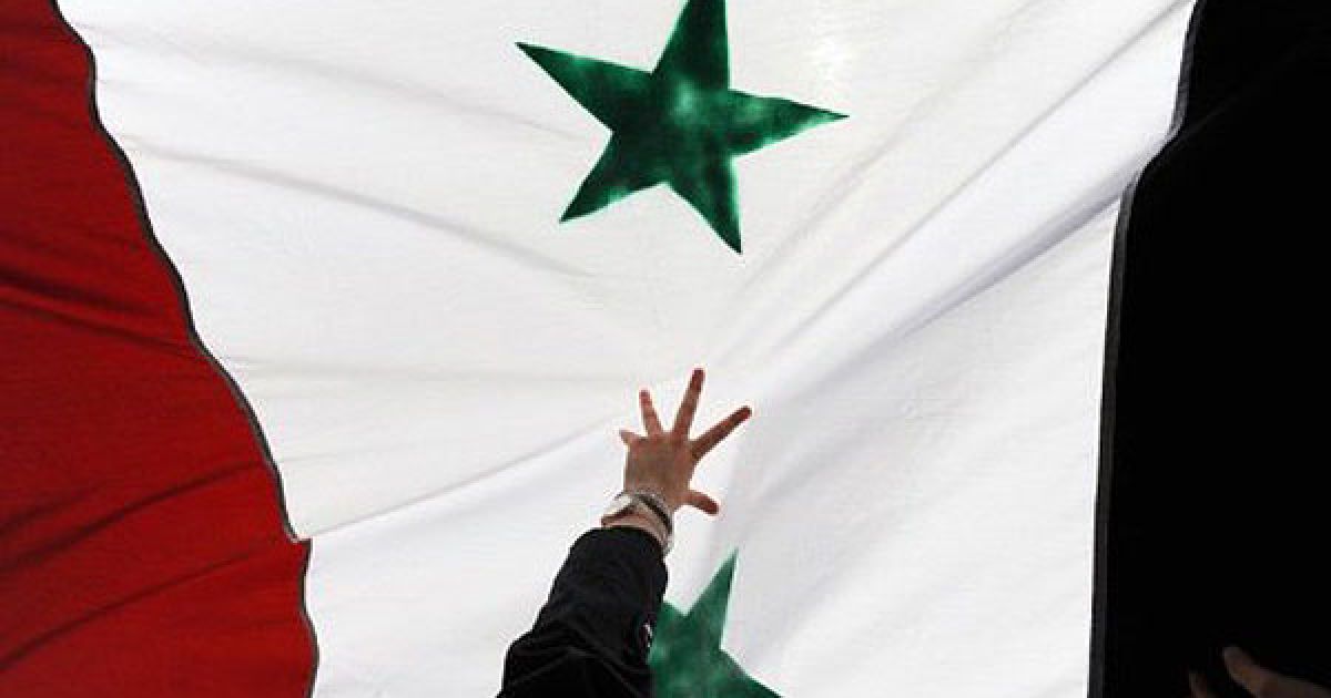 Туреччина, Стамбул. Жінка тримає сирійський прапор під час демонстрації сирійців, що проживають у Туреччині, проти режиму президента Сирії Башара аль-Асада. Сили Асада вбили щонайменше 1486 цивільних осіб під час боротьби з повстанням, що почалось в Сирії у березні 2011 року. / © AFP