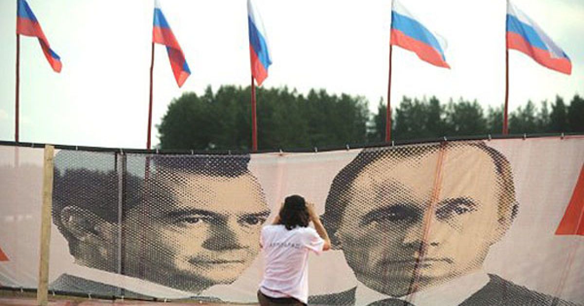 Учасники Всеросійського форуму на озері Селігер роблять вправи перед портретами Мєдвєдєва і Путіна та вивчають добро. / © AFP