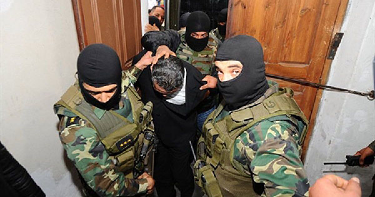 Туніс, Туніс. Сина колишнього президента країни Бен Алі Імеда Трабелсі співробітники сил безпеки ескортують до Палацу правосуддя в Тунісі. Сина екс-президента звинувачують у наркоторгівлі. / © AFP