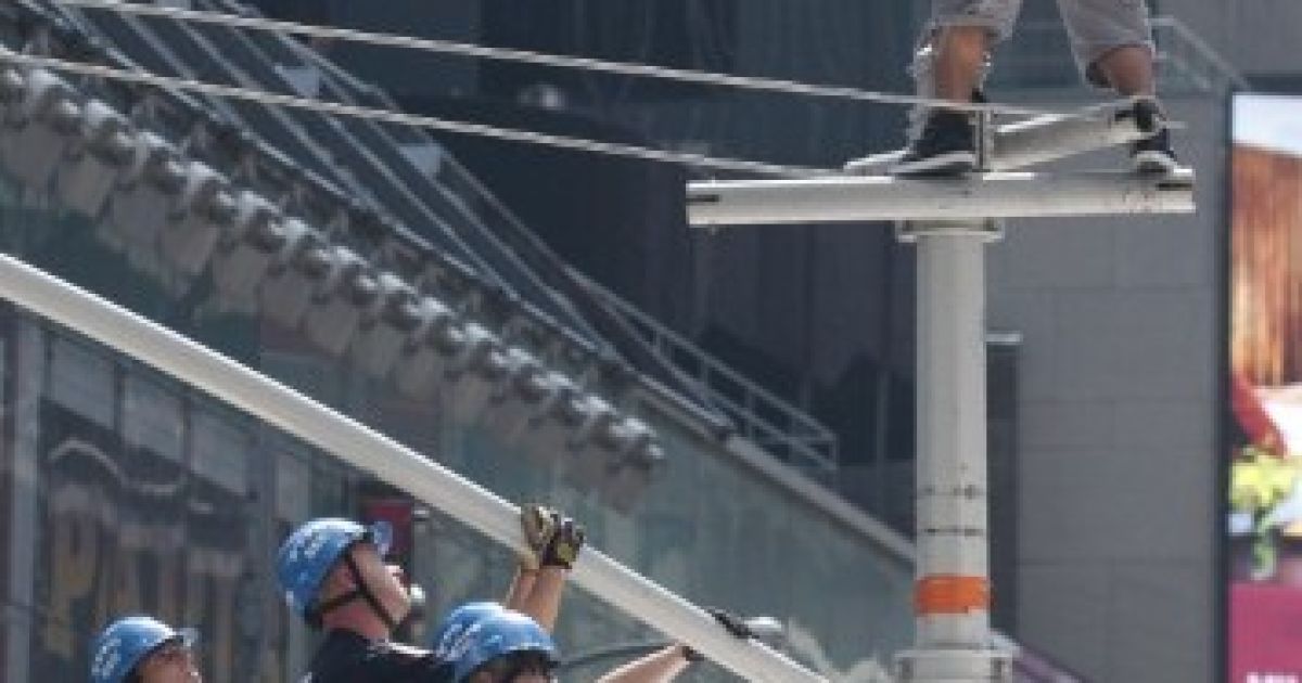 США, Нью-Йорк. Офіцери нью-йоркської поліції ведуть переговори з людиною, яка забралася на ліхтар на Таймс-сквер в Нью-Йорку. Таймс-сквер був закритий після того, як невідомий чоловік заліз на стовп і пригрозив зістрибнути. / © AFP