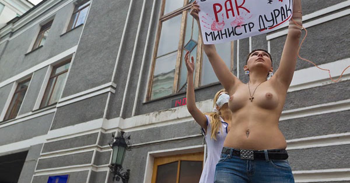 Активістка FEMEN протестувала топлес з плакатами "Я помираю, а ви крадете!", "Епідемія раку совісті", "Momento mori, Yemets!" і "У мене рак, міністре дурак". / © Жіночий рух FEMEN