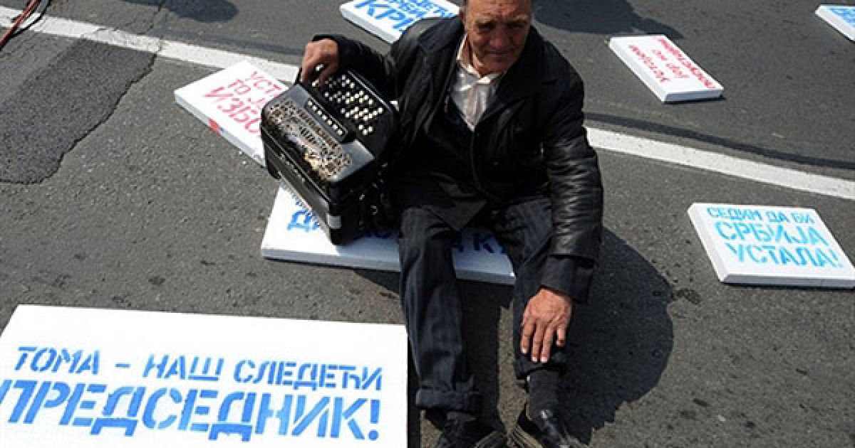 Сербія, Белград. Прихильник лідера Партії прогресу Томіслава Ніколіча сидить поруч із плакатом "Тома &mdash; наш наступний президент" під час мітингу в Белграді. Десятки тисяч демонстрантів взяли участьу антиурядій акцію протесту і вимагали проведення дострокових виборів. / © AFP