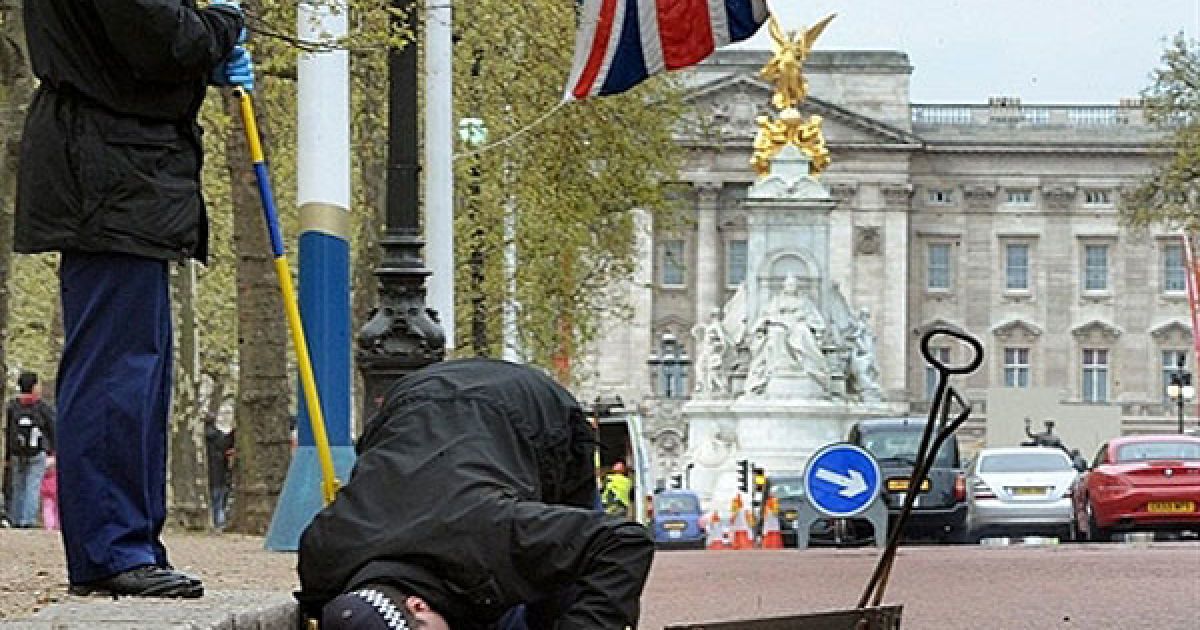 Великобританія, Лондон. Британські поліцейські проводять перевірку стоків вздовж Алеї, що веде до Букінгемського палацу в центрі Лондона. Весілля британського принца Вільяма і Кейт Міддлтон відбудеться у Вестмінстерському абатстві 29 квітня 2011 року. / © AFP