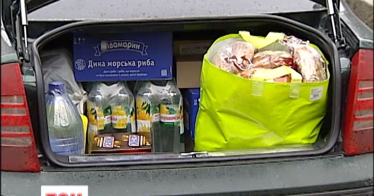 Люди несут лекарства, упаковки воды и коробки с продуктами