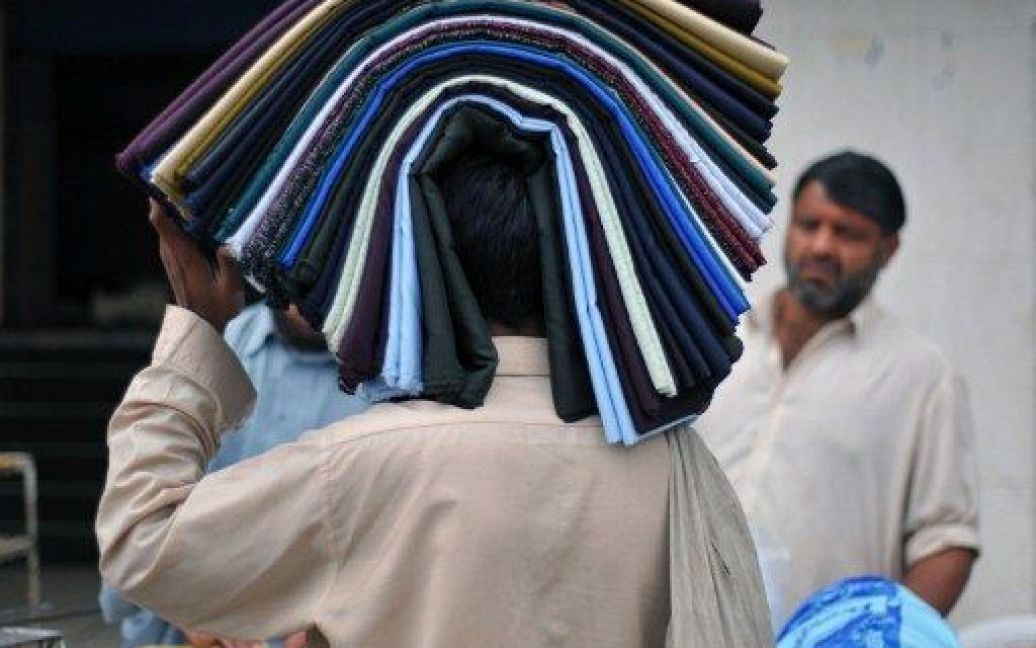 Пакистан, Равалпінді. Торговець несе на голові свій товар вулицями міста Равалпінді. / © AFP