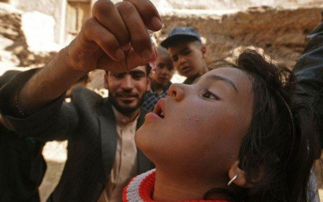 Афганістан, Герат. Медпрацівник дає дитині вакцину проти поліомієліту під час загальнонаціональної кампанії з вакцинації та імунізації в Гераті. / © AFP