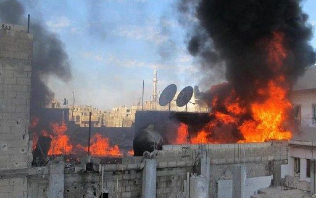 Сирія, Гомс. Пожежа спалахнула на даху будівлі у передмісті Гомса, ймовірно, під час бомбардування міста. Сирійські війська почали масований обстріл повстанських районів міста. Фото AFP/HO/ LCC SYRIA / © AFP