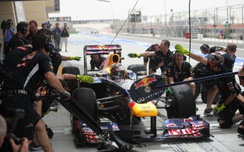 Бахрейн, Манама. Механіки лагодять автомобіль німецького гонщика команди Red Bull Racing Себастьяна Феттеля у боксах напередодні змагань Формули-1 на Гран-прі Бахрейну. / © AFP