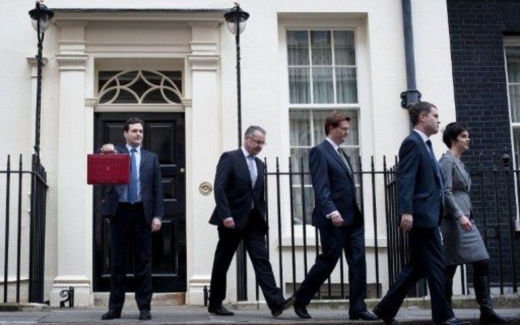 Великобританія, Лондон. Міністр фінансів Великобританії Джордж Осборн демонструє портфель з річним бюджетом перед поданням документу до парламенту. Це вже третій бюджет, який склав британський коаліційний уряд, щоб скоротити величезний дефіцит. / © AFP