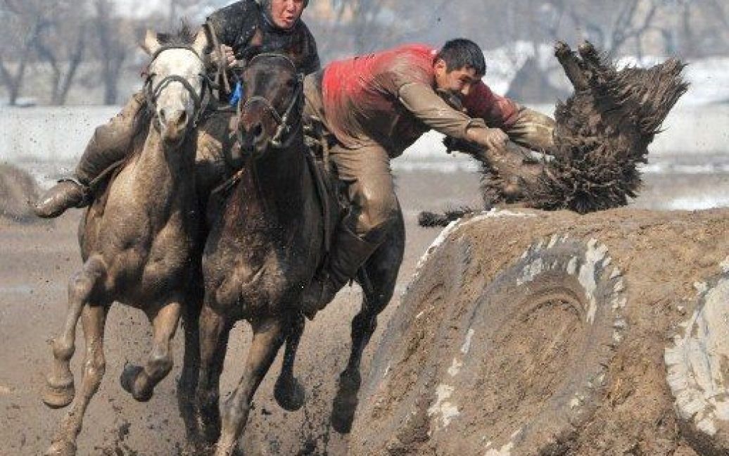 Киргизстан, Бішкек. Учасники традиційних у Центральній Азії змагань "Бузкаші", або Кок-бору, кидають опудало вівці у колодязь. / © AFP