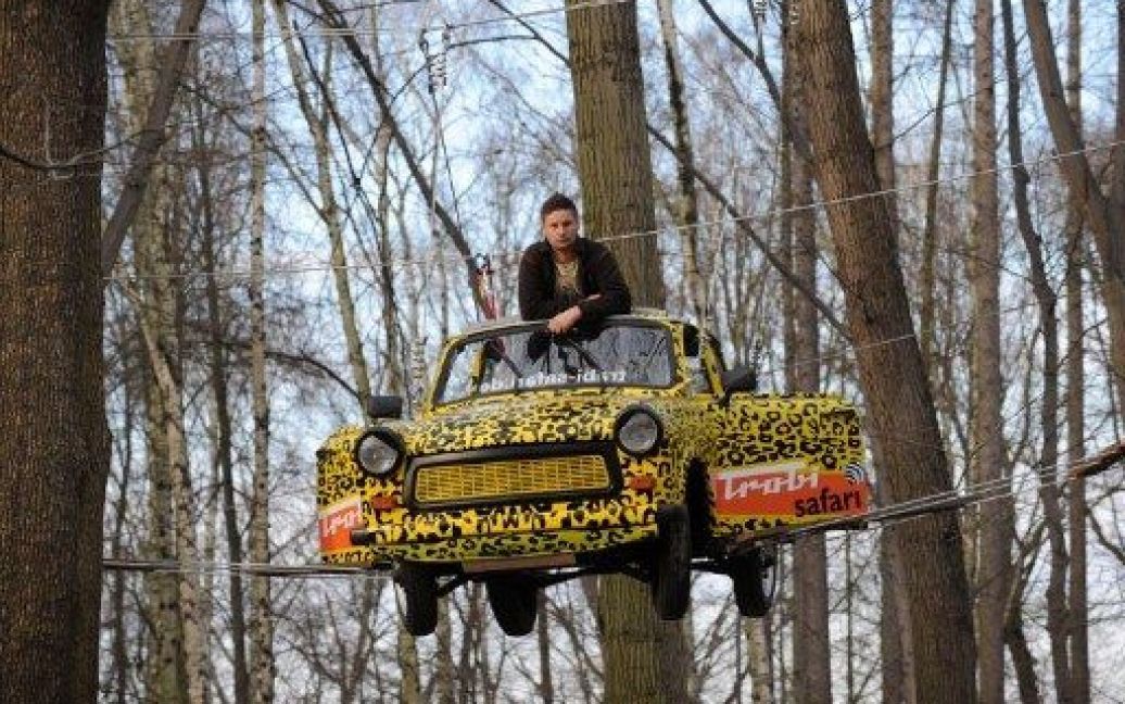 Німеччина, Моріцбург. Автомобільний дизайнер Maik Dannewitzsch закріпив старий "Трабант" ("Трабі") у мотузковому парку пригод поблизу Дрездена, східна Німеччина. Автомобіль стане новим атракціоном у парку розваг. / © AFP