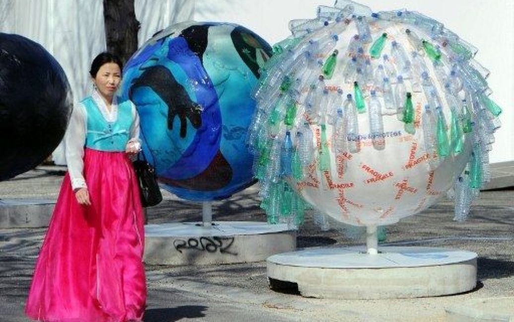 Франція, Марсель. Жінка проходить повз прикрашену пластиковими пляшками води кулю, яку встановили у Марселі з нагоди проведення 6-го Всесвітнього водного форуму. / © AFP
