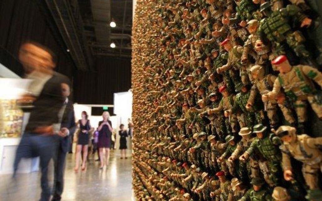 ОАЕ, Дубай. Відвідувачі 6-ої виставки Art Dubai проходять повз інсталяцію художника Хелала Таєра, яка складається з десятків пластикових солдатиків і відображає погляд художника на військовий конфлікт у його країні. / © AFP