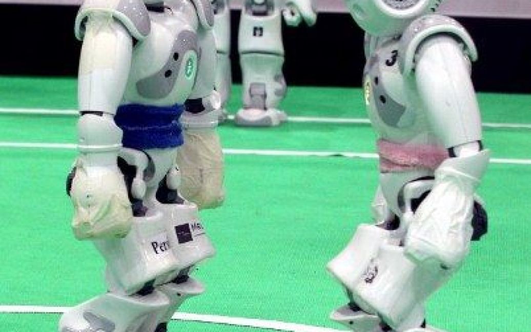 Іран, Тегеран. Робот з команди Університету Ірану Qazvin Islamic Azad та робот голландської команди Dutch Nao Team (Ван-Амстердамський університет) беруть участь у футбольному матчі на Відкритому Кубку роботів RoboCup 2012. / © AFP