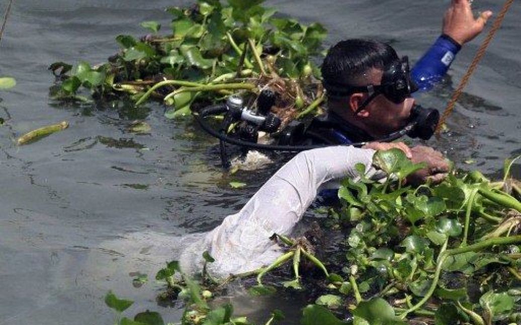 Бангладеш, Маншигонг. Рятувальник дістає з-під води тіло пасажира, який загинув під час аварії порому на річці. Щонайменше семеро людей загинули, близько 150 осіб пропали безвісти в результаті інциденту, 35 людей вижили. / © AFP