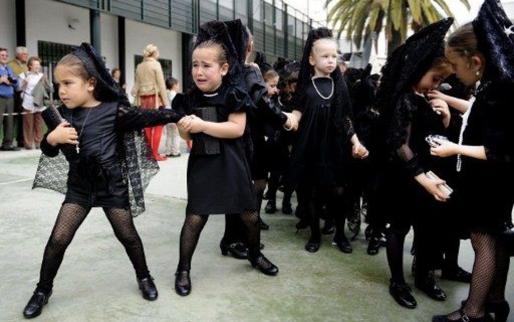 Іспанія, Севілья. Дівчата у традиційних чорних мантильях беруть участь у ході в школі Богоматері Розарії в Севільї напередодні Страсного тижня. / © AFP