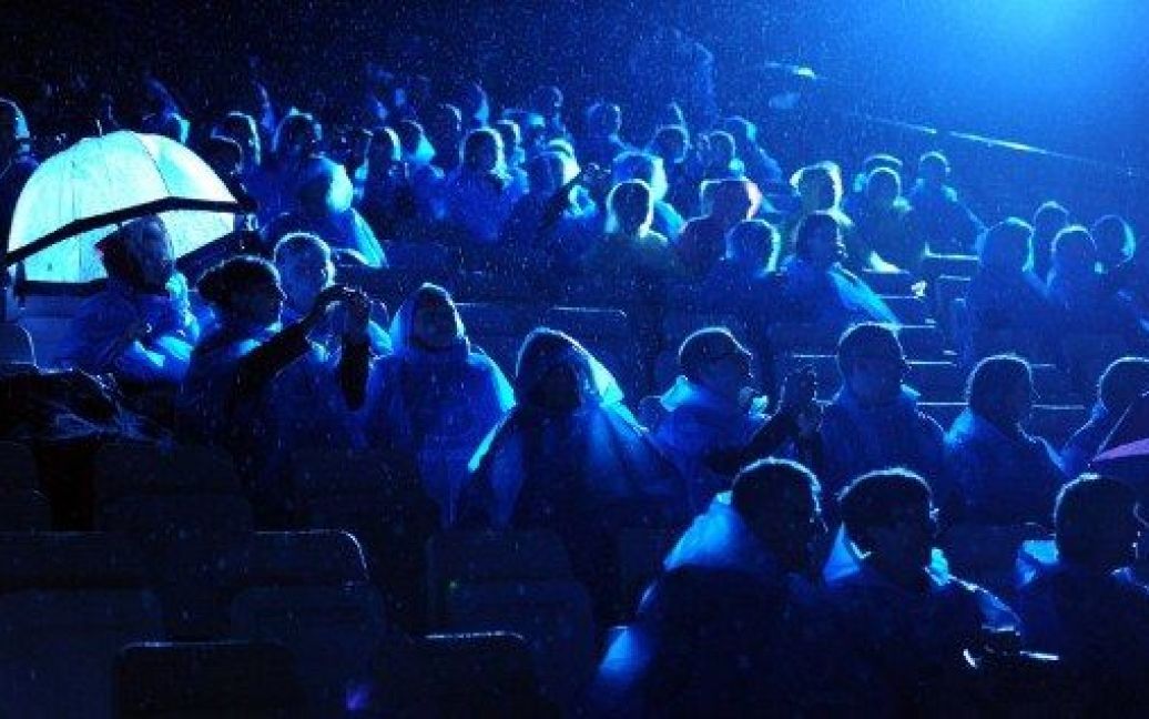 Австралія, Сідней. Шанувальники опери у пластикових пончо під дощем дивляться генеральну репетицію "Травіати" у гавані Сіднея. / © AFP