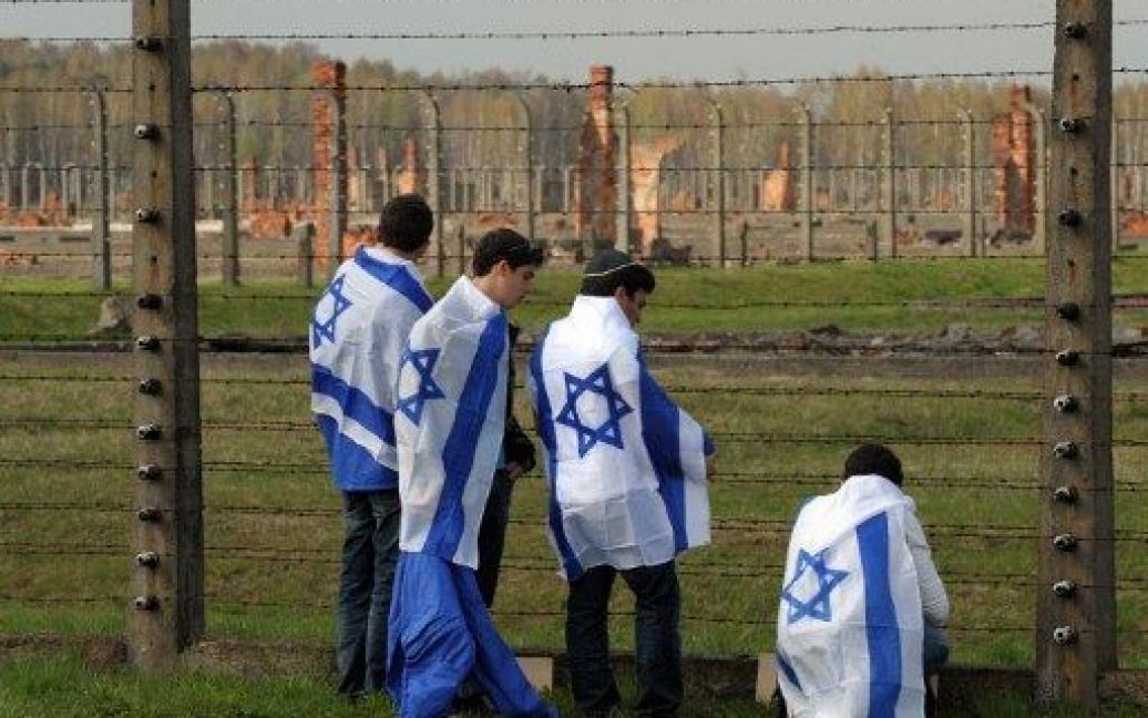 Польща, Освенцім. Юнаки, загорнуті у ізраїльські прапори, беруть участь у Марші живих, який стартував у таборі смерті "Освенцім-Біркенау" в Польщі. Щорічний Марш живих проводять на згадку про 6 млн євреїв, убитих під час Голокосту. / © AFP
