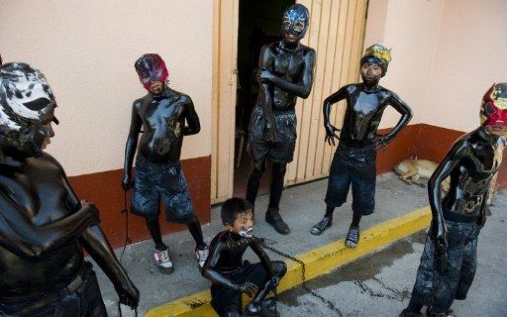 Мексика, Сан Ніколас де Лос Ранчо. Хлопчики із розфарбованими чорним тілами та у масках беруть участь у традиційному фестивалі "Los Pintados" у Мексиці. / © AFP