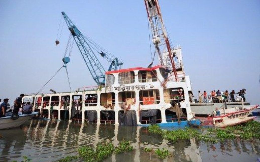 Бангладеш. Робочі піднімають уламки порому, який затонув на річці на півдні країни. В результаті аварії порому з 200 пасажирами на борту, загинули більше 100 осіб. / © AFP