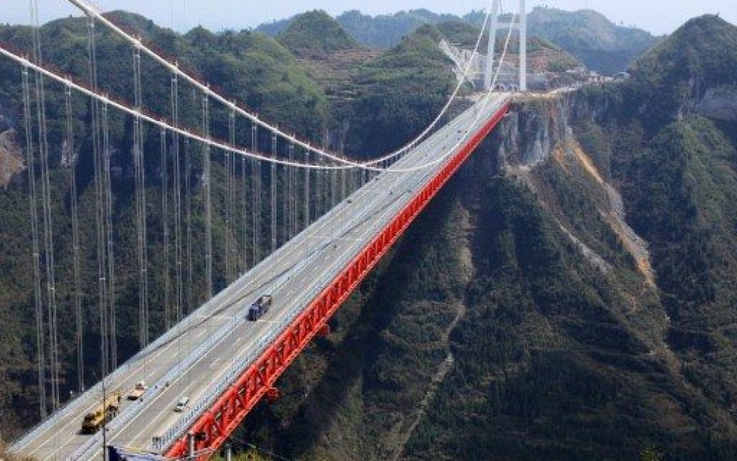 Китай, Jishou. Міст Aizhai вважають одним із найвищих тунелів у світі, він розташований на висоті 336 метрів і має довжину 1176 метрів. Міст Aizhai є четвертим підвісним мостом в Китаї, який з&#039;єднує дві гірські ланцюги. / © AFP