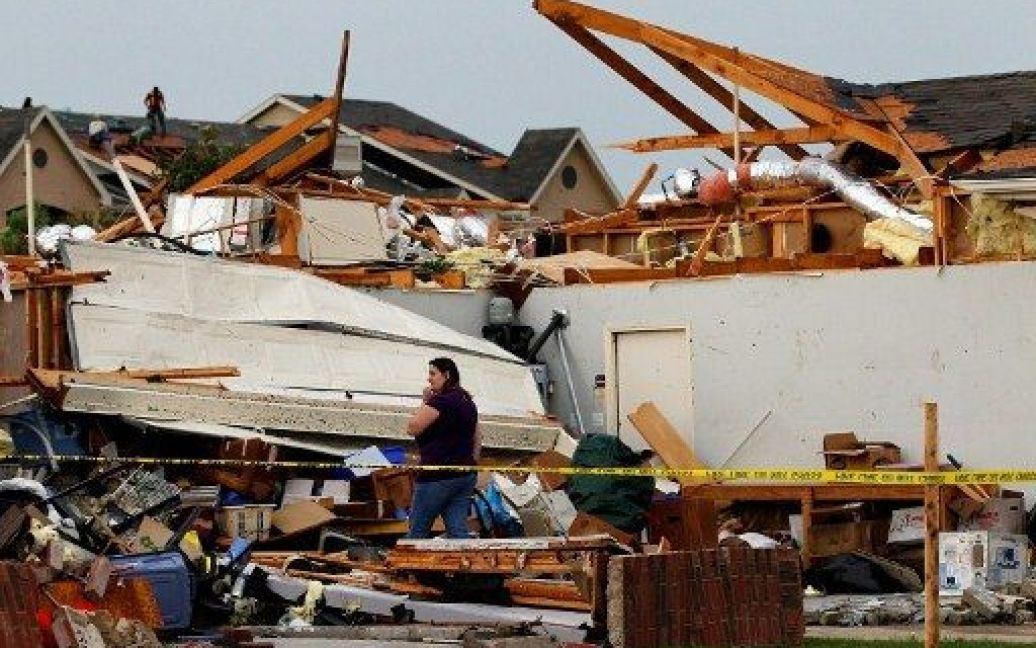 США, Арлінгтон, штат Техас. Жінка шукає вцілілі речі на руїнах свого будинку, який знесло потужним торнадо. Кілька смерчів і торнадо налетіли на міста Даллас і Форт-Уерт в штаті Техас. / © AFP