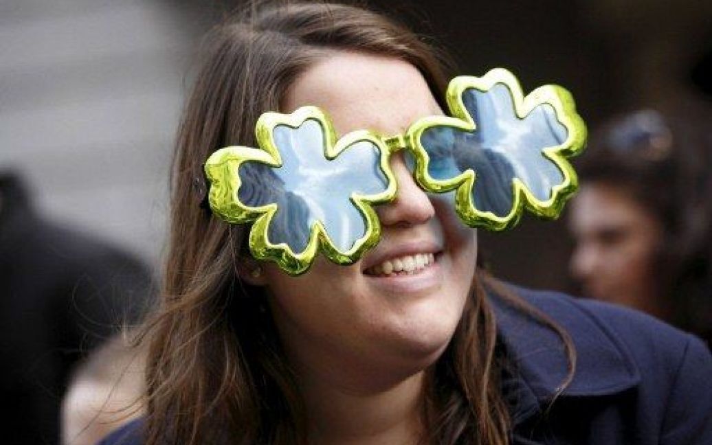 Великобританія, Лондон. Жінка у сонцезахисних окулярах у формі трилисника бере участь у параді з нагоди Дня Святого Патрика в Лондоні. / © AFP
