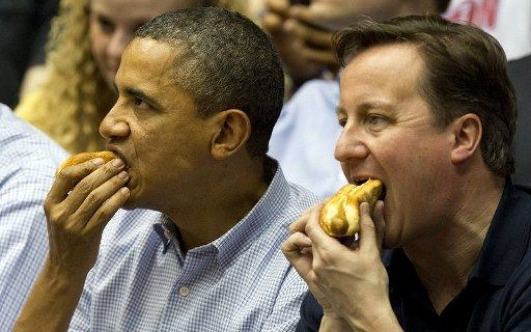 США, Дейтон. Президент США Барак Обама і прем&#039;єр-міністр Великобританії Девід Кемерон їдять хот-доги під час відвідування баскетбольного матчу в університеті Дейтони, штат Огайо. / © AFP