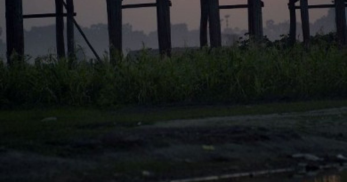 М'янма, Мандалай. Мешканці перетинають відомий міст "У Бейн" на озері Таунгтаман під час заходу сноця. Міст "У Бейн" є найдовшим та найстарішим мостом у світі, створеним з тикового дерева, його довжина становить близько 1,2 км. / © AFP