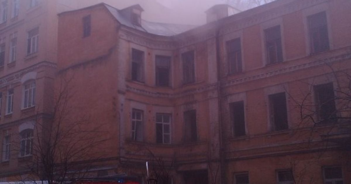 З вікон і даху будинку валить дим.