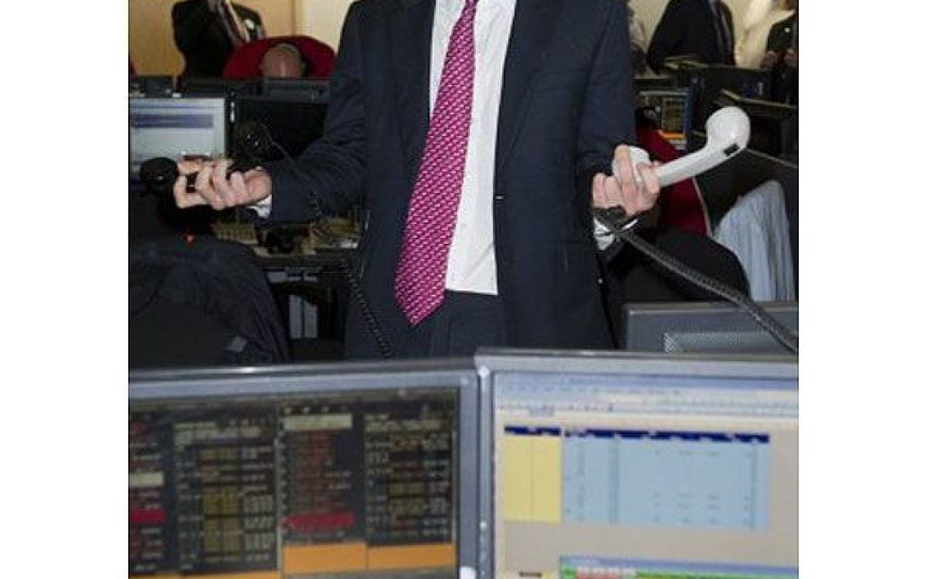 Великобританія, Лондон. Британський принц Гаррі тримає в руках телефони під час участі у благодійному дні "BGC Partners" на біржі в Лондоні. / © AFP