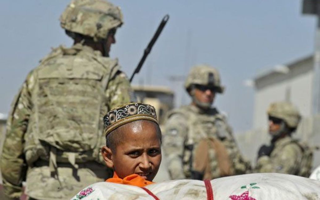 Афганістан, Терхам. Хлопчик спостерігає, як солдати американської армії здійснюють патрулювання вулиць міста на кордоні з Пакистаном. / © AFP