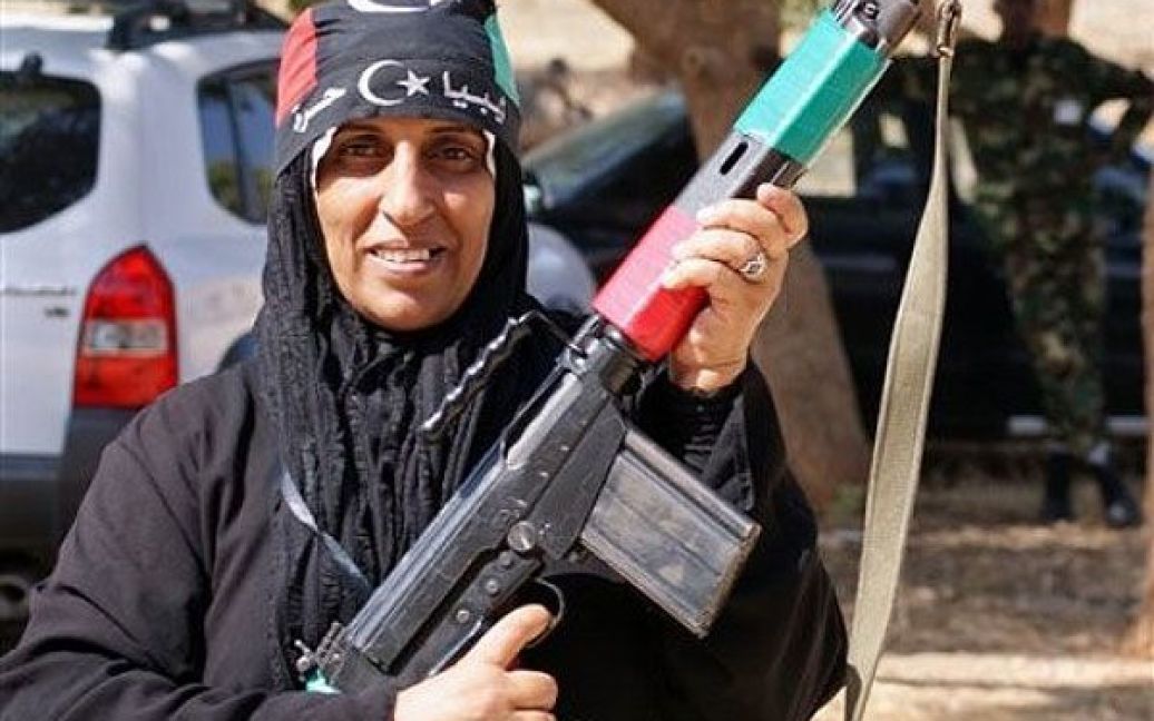 Лівійська Арабська Джамахірія, Бенгазі. Жінка тримає зброю під час проходження військової підготовки, яку пропонують жінкам сили Перехідної національної ради. Жінок шикуються в чергу, щоб бути готовими захистити свої міста і себе, якщо сили Муаммара Каддафі спробують повернутися. / © AFP