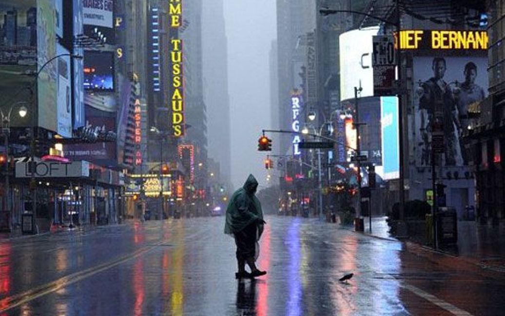 США, Нью-Йорк. Людина під парасолькою йде по 42-ою вулицею в Нью-Йорку. Ураган Айрін обрушився на місто та його околиці з потужним вітром та проливними дощами. Щонайменше, дев&#039;ятеро осіб загинули в результаті стихії на східному узбережжі США. / © AFP