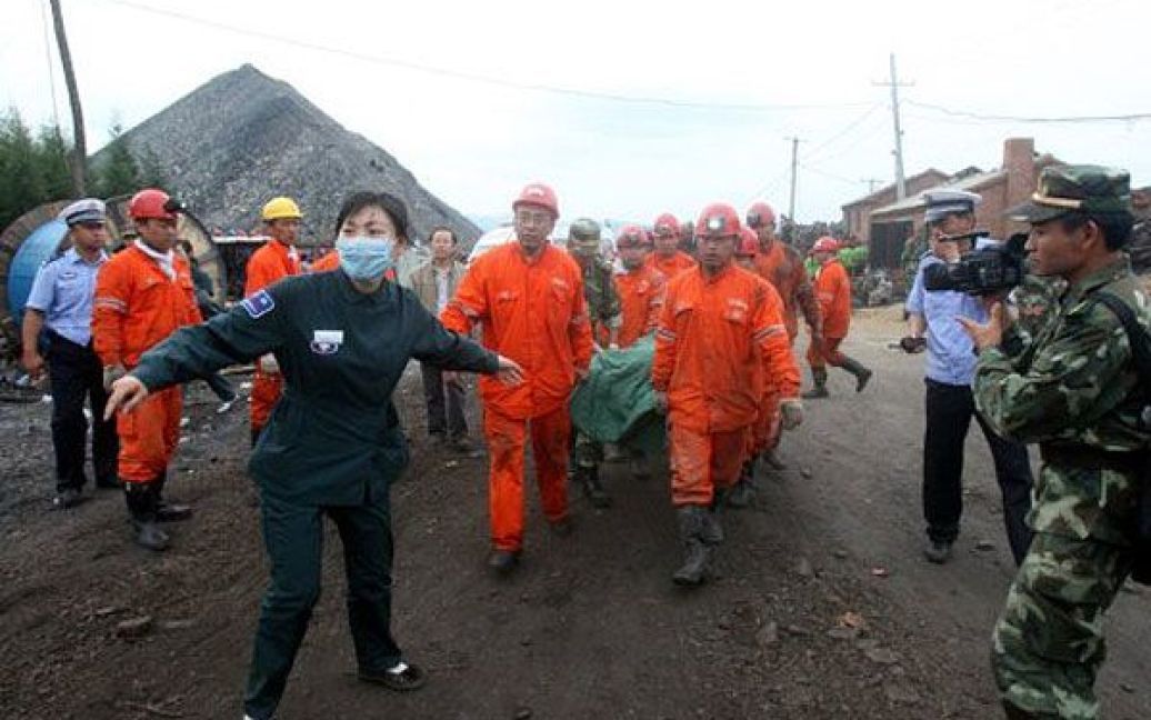 Китай, Цитайхе. Рятувальники несуть шахтаря, якого підняли з затопленої шахти у місті Цитайхе на північному сході Китаю. 19 шахтарів, які потрапили у пастку у затопленій шахті, були врятовані. / © AFP