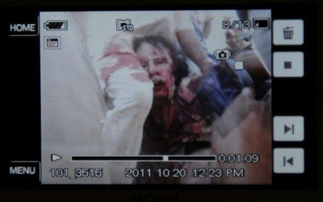 Телеканал "Аль-Джазіра" показав шокуючий відеозапис, на якому прихильники ПНР Лівії тягнуть напівоголене тіло Муамара Каддафі по вулиці / © AFP