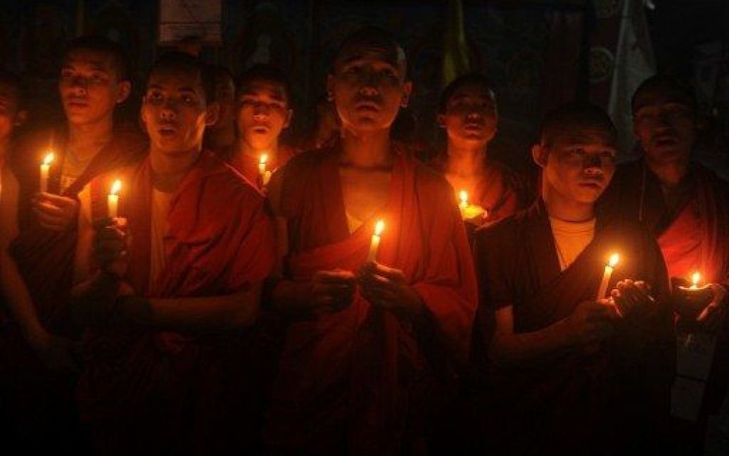 Індія, Сілігурі. Тибетські ченці та прихильники Тибету тримають запалені свічки під час участі у мітингу солідарності з Тибетом на околиці Сілігурі. Тибетці, які живуть у вигнанні в Індії, почали протести по всій Індії після кількох актів самоспалення серед буддійських ченців. / © AFP