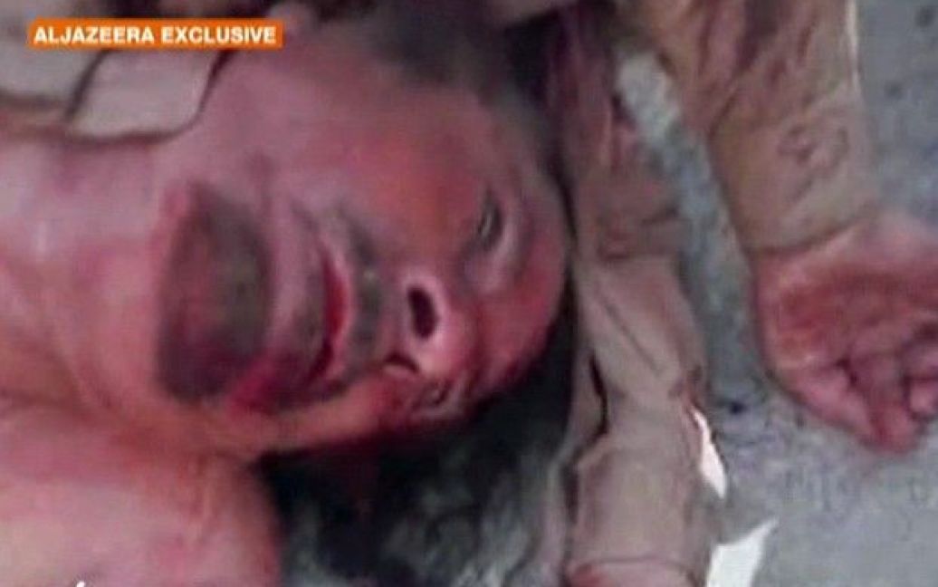 Телеканал "Аль-Джазіра" показав шокуючий відеозапис, на якому прихильники ПНР Лівії тягнуть напівоголене тіло Муамара Каддафі по вулиці / © Al Jazeera