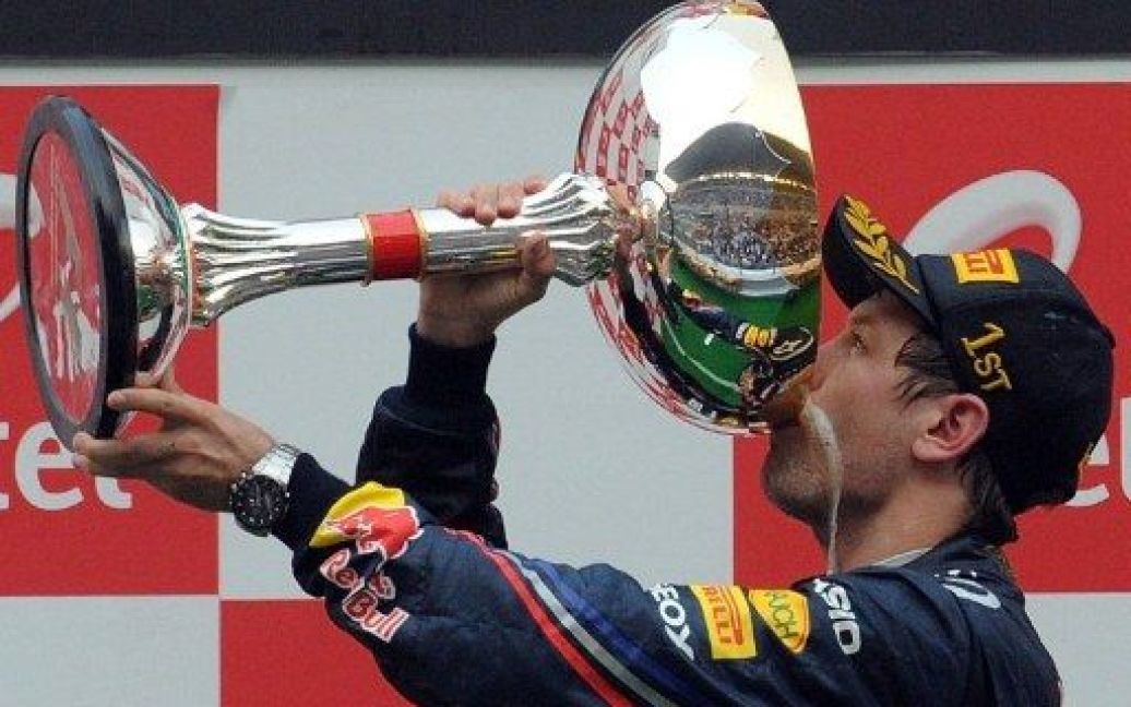 Індія, Грейтер Нойд. Німецький гонщик Red Bull-Renault Себастьян Феттель п&#039;є шампанське зі свого кубка після перемоги у індійському Гран-прі Формули-1. Чемпіон світу Себастьян Феттель увійшов в історію, вигравши перші в історії Індії гонки Формули-1. / © AFP