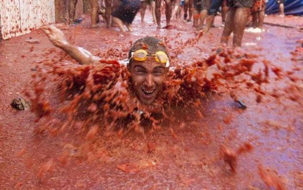 Іспанія, Буньоль. Більше 40 тисяч людей з усього світу взяли участь у "помідорній" битві на вулицях міста Буньоль, поблизу Валенсії. На щорічне свято "Томатіна" привезли 120 тонн томатів, якими закидували один одного учасники фестивалю. / © AFP