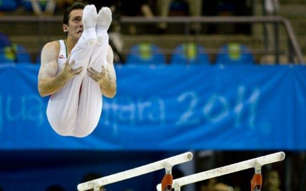 Мексика, Гвадалахара. Мексиканський гімнаст Хав&#039;єр Сервантес виступає на брусах під час чоловічої кваліфікації на XVI Панамериканських іграх в Гвадалахарі. / © AFP