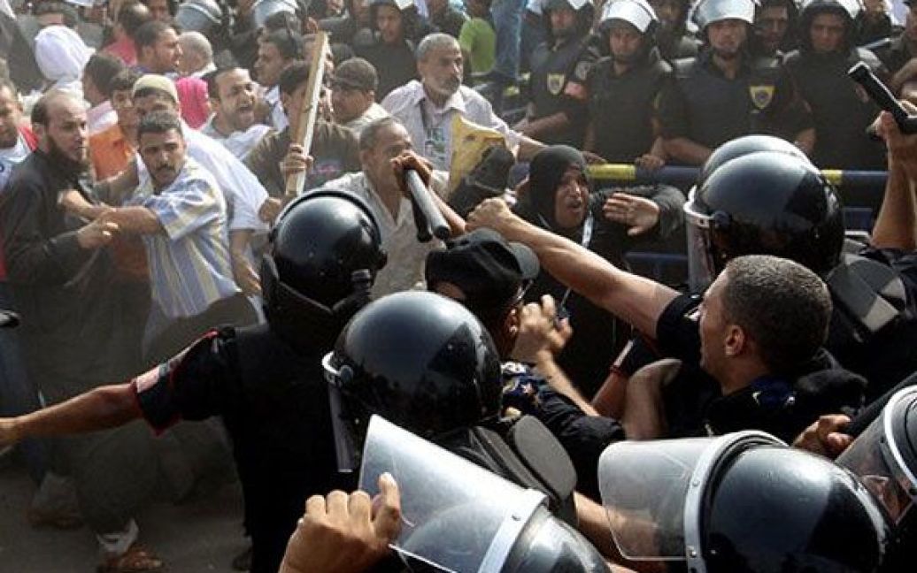 Єгипет, Каїр. Єгипетські поліцейські зупиняють демонстрантів під час акції протесту проти екс-президента країни Хосні Мубарака. Демонстрантів зупинили по дорозі до суду, де поновився розгляд справи колишнього президента Єгипту. / © AFP
