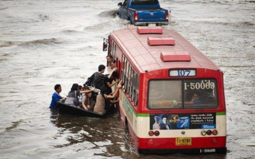 Таїланд, Бангкок. Пасажири пересідають з човна на автобус на затопленій вулиці в районі магазинів Lat Phrao в Бангкоку. / © AFP