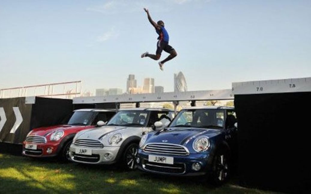 Великобританія, Лондон. Надія британської легкої атлетики, спортсмен Джей Джей Джегеде, який представлятиме країну на Олімпійських іграх 2012 в Лондоні, тренується у стрибках у довжину через дах з трьох автомобілів Mini. / © AFP